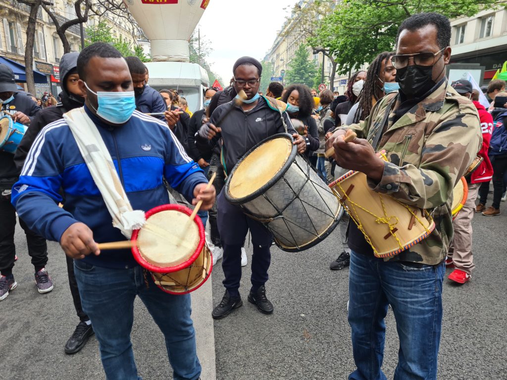 Des manifestants qui jouent des percussions
