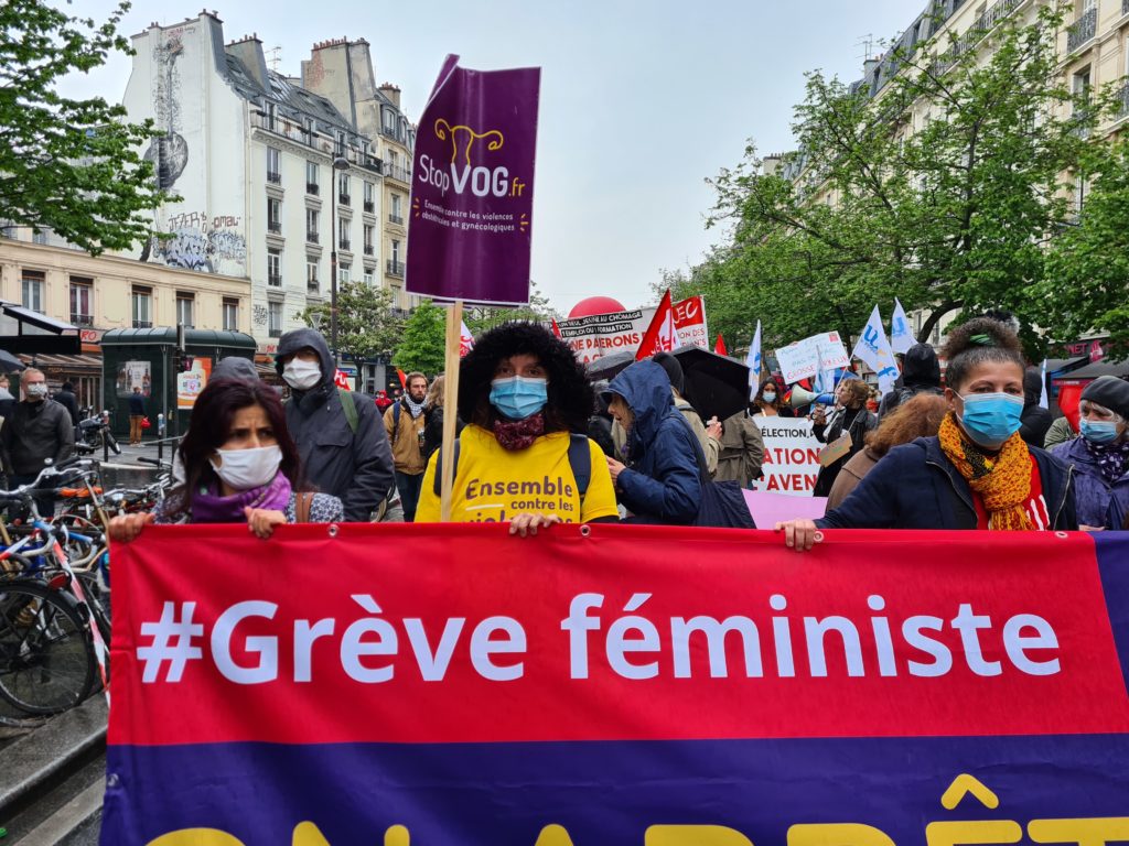 Photo de la foule qui manifeste avec une banderole rouge "#Grève féministe"